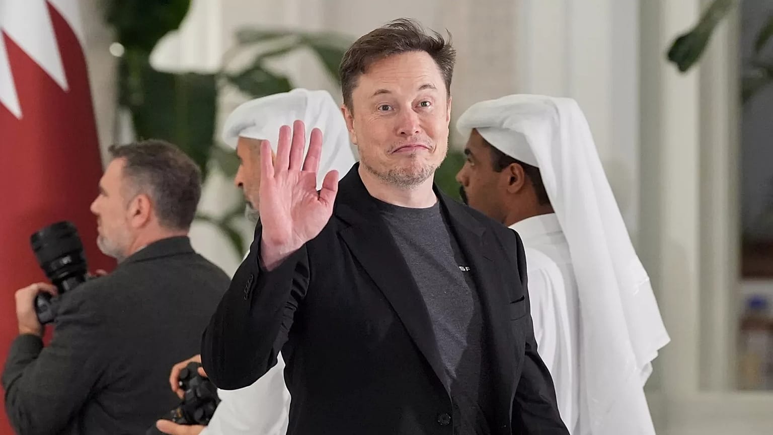 lon Musk, Katar Emiri Şeyh Tamim bin Hamad Al Thani'nin Başkan Donald Trump onuruna Doha, Katar'daki Lusail Sarayı'nda verdiği devlet yemeğine gelirken el kol hareketleri yapıyor.