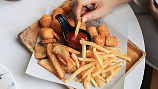 Una persona come patatas fritas.