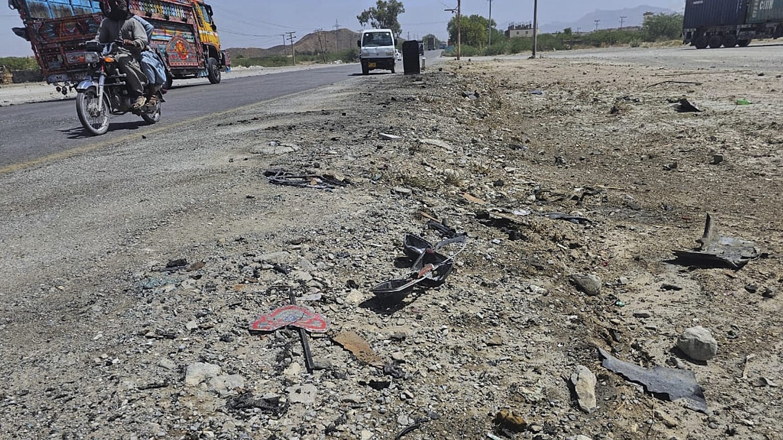 Bir motosiklet ve diğer araçlar, 21 Mayıs 2025 tarihinde Pakistan'ın güneybatısındaki Khuzdar şehrinin eteklerindeki bir otoyolda meydana gelen intihar saldırısının gerçekleştiği yerden geçiyor.