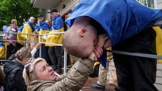 Un soldado ucraniano besa la mano de una mujer tras regresar de su cautiverio en un intercambio de prisioneros de guerra en Ucrania, martes 6 de mayo de 2025.