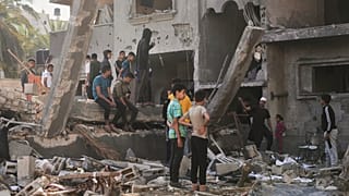فلسطینیان خانه‌ای را که در اثر حملات هوایی اسرائیل در دیر البلح ویران شده بررسی می‌کنند،  روز چهارشنبه، ۲۱ مه ۲۰۲۵