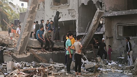 Palestinians inspect a house destroyed by an Israeli airstrikes in Deir al-Balah, Gaza, Wednesday, May 21, 2025.