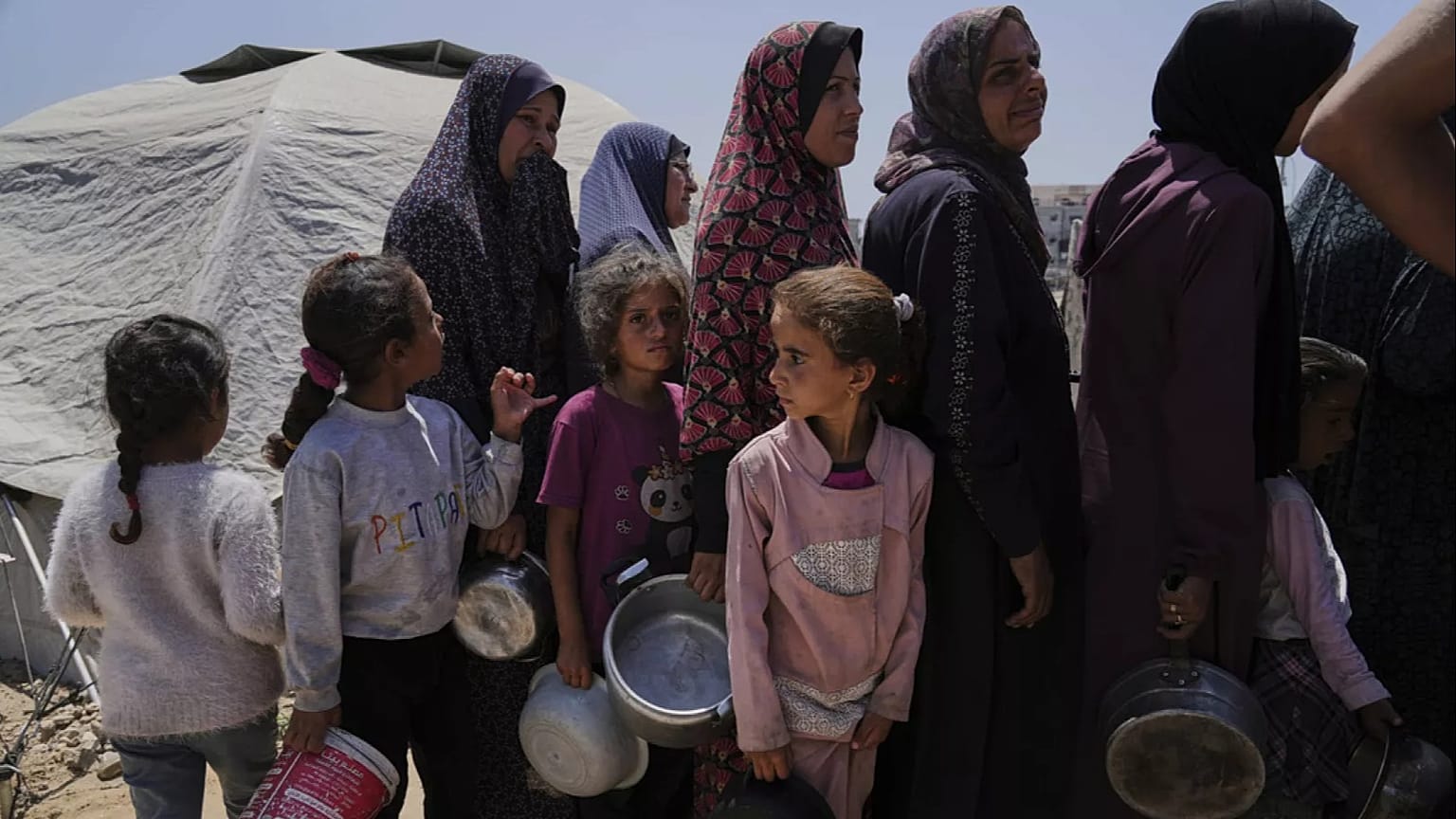 نازحون فلسطينيون يصطفون للحصول على وجبات مقدّمة من مطبخ خيري داخل مخيم خيام في مدينة غزة، يوم الأربعاء 21 مايو 2025.