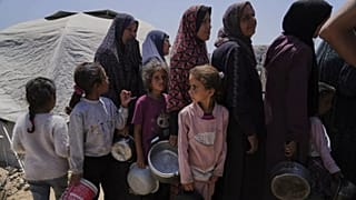 نازحون فلسطينيون يصطفون للحصول على وجبات مقدّمة من مطبخ خيري داخل مخيم خيام في مدينة غزة، يوم الأربعاء 21 مايو 2025.