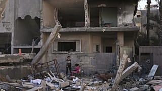 Palestinians inspect a house destroyed by an Israeli air strike in Deir al-Balah, 21 May, 2025