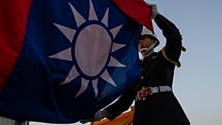 A soldier lowers the Taiwan national flag during the daily flag ceremony at the Chiang Kai-shek Memorial Hall in Taipei, 12 January, 2025