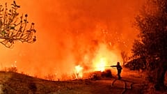 Um bombeiro tenta extinguir as chamas perto da aldeia de Kallithea, 29 de setembro de 2024