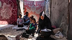 Nouf Al-Arja, dreißig Jahre alt und an Unterernährung leidend, kocht für ihre Familie in ihrem Zelt in einem Lager für vertriebene Palästinenser in Muwasi, Khan Younis, Gaza, am 21.05.2025.