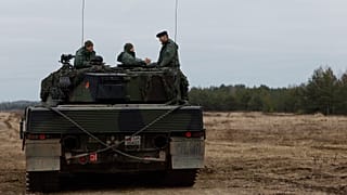 FILE: Ukrainian and Polish soldiers sit on top of a Leopard 2 tank during a training at a military base and test range in Swietoszow, 13 February 2023