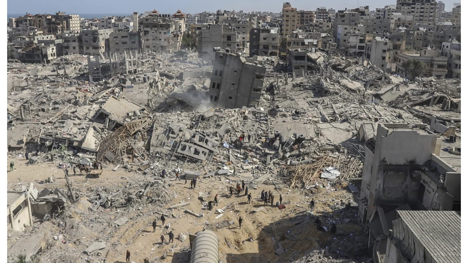 فلسطينيون يسيرون بين الركام في محيط مستشفى الشفاء بغزة. 1 أبريل 2024