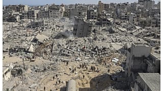 فلسطينيون يسيرون بين الركام في محيط مستشفى الشفاء بغزة. 1 أبريل 2024