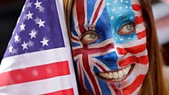 فتاة تضع على وجهها علم أمريكا وبريطانيا