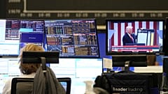 Egy kereskedő a frankfurti tőzsdén Trumpt nézi egy hírcsatornán