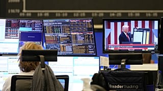 Egy kereskedő a frankfurti tőzsdén Trumpt nézi egy hírcsatornán