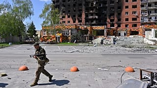 یک سرباز اوکراینی از ساختمان های آسیب دیده در مرکز پوکروسک، محل سنگین ترین نبردها با نیروهای روسی در منطقه دونتسک، قدم می‌زند، ۲۵ آوریل ۲۰۲۵