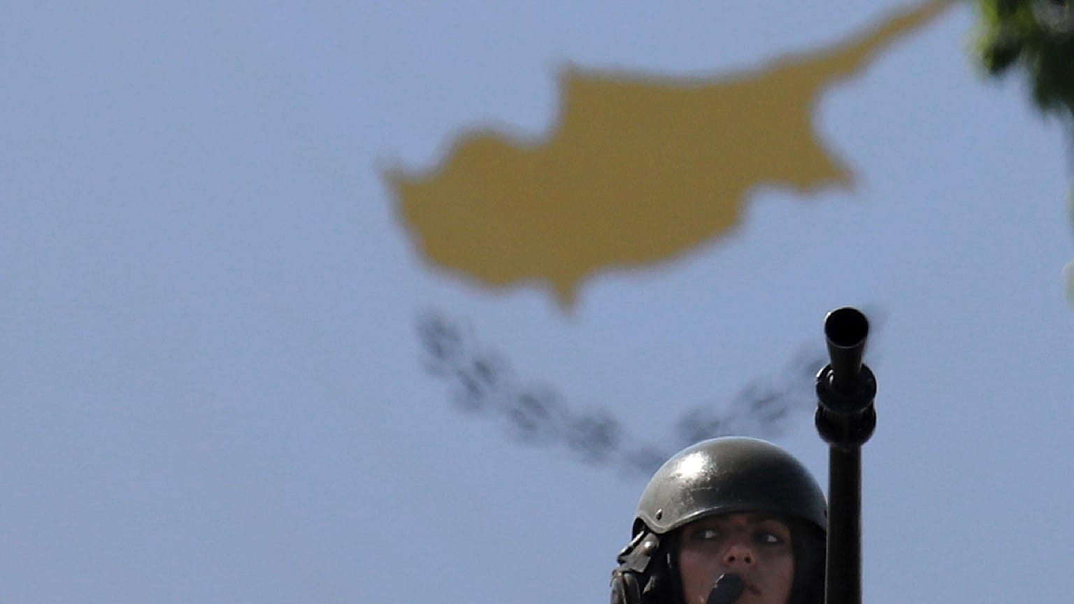 Lefkoşa'da bağımsızlığın 59. yılı kutlamaları çerçevesinde düzenlenen askeri geçit töreni sırasında Kıbrıs bayrağı önünde Kıbrıslı bir kadın asker, 1 Ekim 2019