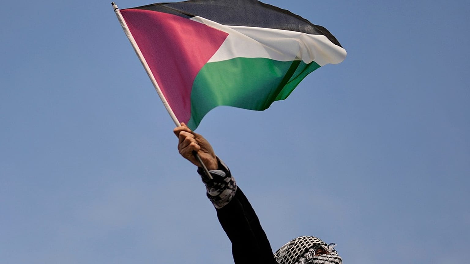 متظاهر يلوّح بالعلم الفلسطيني خلال وقفة مؤيدة لفلسطين أمام القنصلية الإسرائيلية في إسطنبول، 6 نيسان/ أبريل 2025.