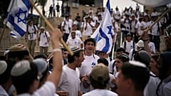 Israelis schwenken während eines Marsches in der Altstadt von Jerusalem am Montag, dem 26. Mai 2025, Nationalflaggen.