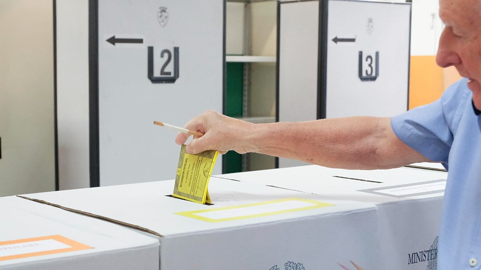 Un elettore mette la sua scheda elettorale nell'urna in un seggio di Torino in occasione del referendum del 12 giugno 2022