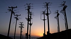 Ege Denizi'ndeki Tilos adasında güneş elektrik direklerinin arkasından batıyor, 9 Mayıs, 2022