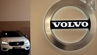En esta foto de archivo del 6 de febrero de 2020, un coche se encuentra aparcado tras el logotipo de Volvo en el vestíbulo de la sede corporativa de la empresa, en Bruselas.
