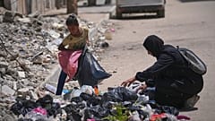Islam Abu Taeima, una madre de cinco hijos de 40 años, y su hija Waed de 9 años buscan comida en un montón de basura en la Ciudad de Gaza, el domingo 25 de mayo de 2025