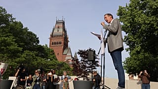 Ryan Enos, professore all'Università di Harvard, parla durante una protesta contro le recenti misure del presidente Donald Trump contro l'ateneo, 27 maggio 2025