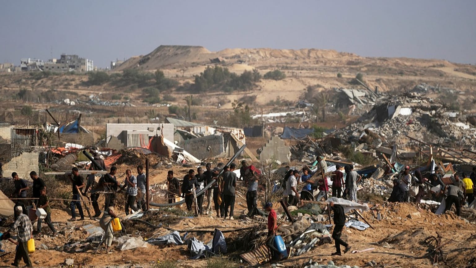 Des Palestiniens se dirigent vers un centre de la Fondation humanitaire pour Gaza (GHF) pour recevoir de la nourriture et de l'aide humanitaire, le mardi 27 mai 2025 