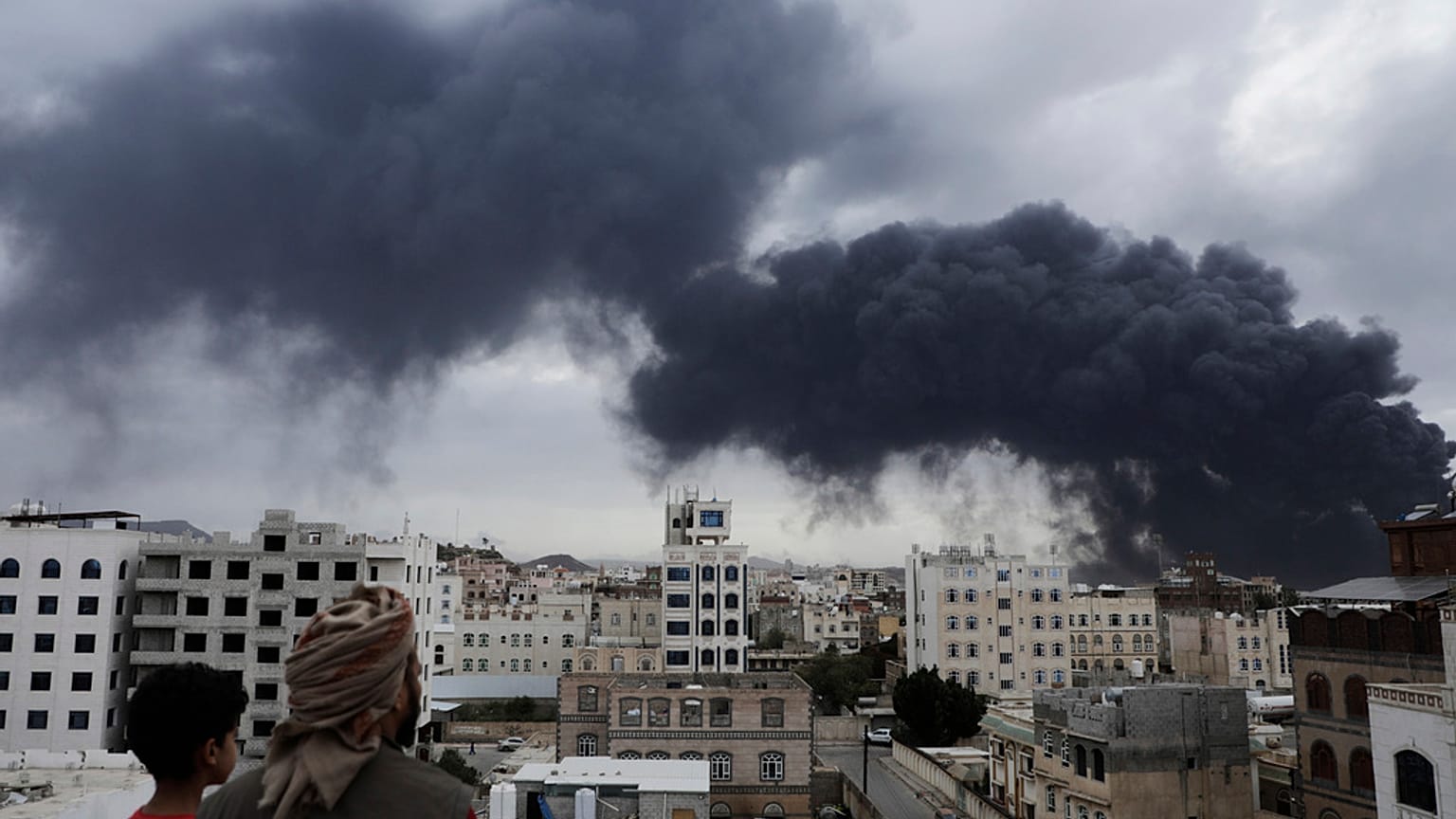 يمنيون يشاهدون تصاعد الدخان عقب غارات جوية إسرائيلية استهدفت محطة لتوليد الكهرباء ومطار صنعاء، في صنعاء، اليمن، يوم الثلاثاء، 6 مايو/أيار 2025. 