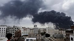 يمنيون يشاهدون تصاعد الدخان عقب غارات جوية إسرائيلية استهدفت محطة لتوليد الكهرباء ومطار صنعاء، في صنعاء، اليمن، يوم الثلاثاء، 6 مايو/أيار 2025. 