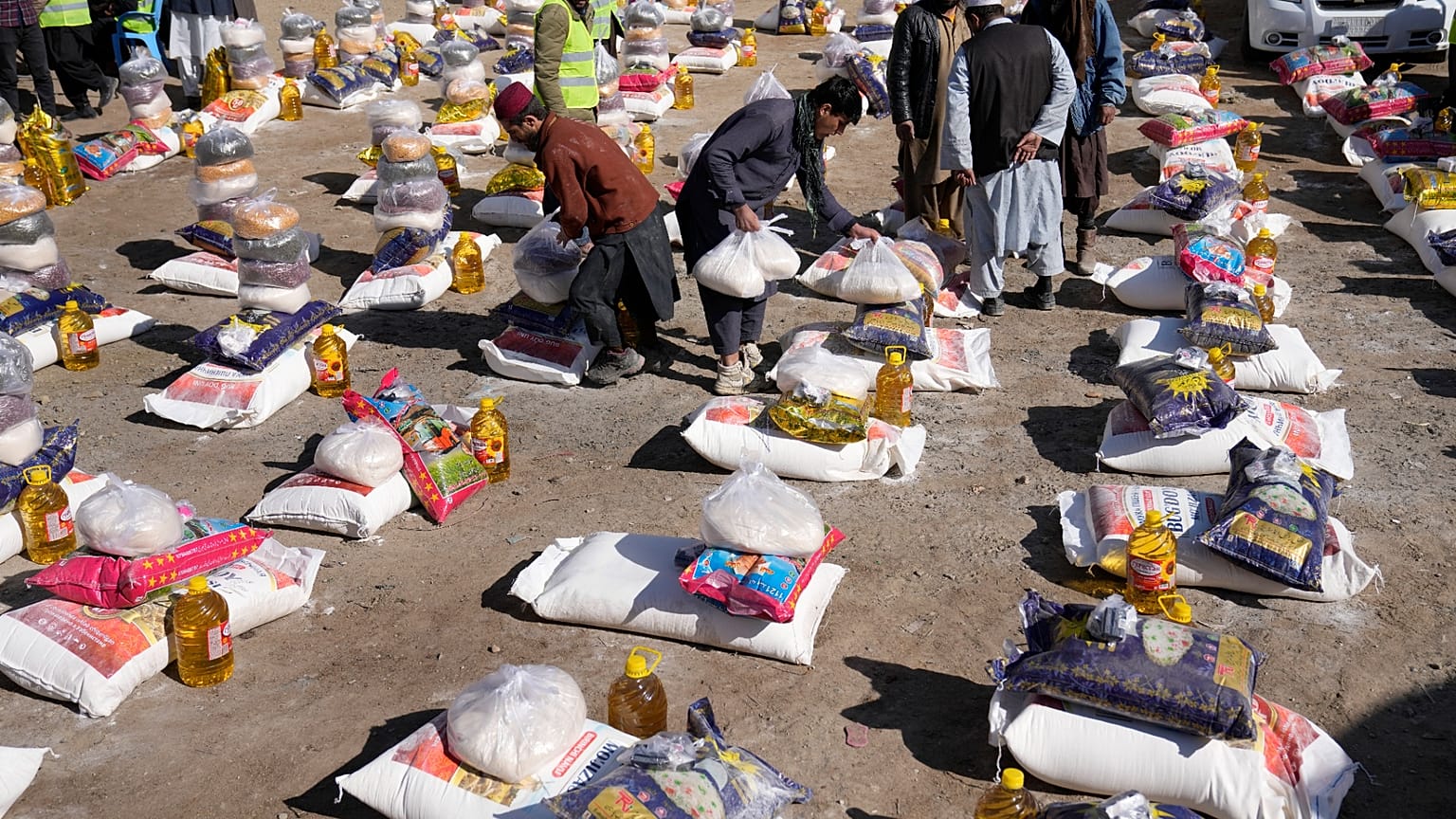 Trabalhadores afegãos preparam alimentos durante uma campanha de ajuda humanitária para famílias pobres, em Cabul, no Afeganistão.