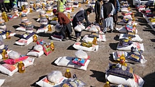 Trabajadores afganos preparan alimentos durante una campaña de ayuda humanitaria para familias pobres, en Kabul, Afganistán.