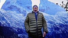 The plaintiff Peruvian farmer Luciano Lliuya stands in front of glacier pictures held by activists at the Higher Regional Court in Hamm, Germany. 