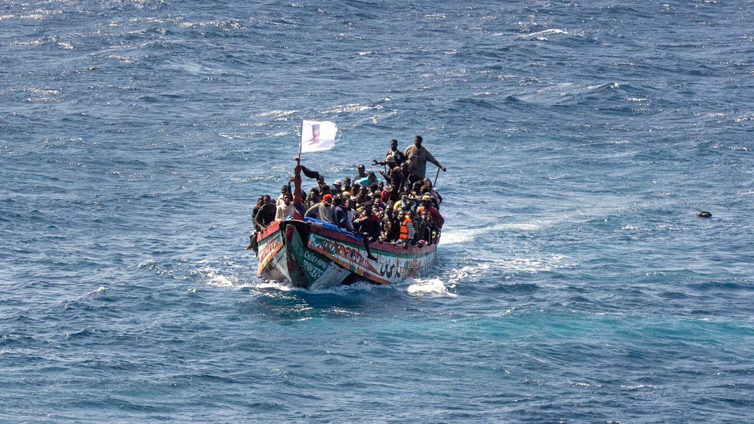 Migrantes apinham-se num barco de madeira enquanto navegam para o porto de La Restinga, na ilha canária de El Hierro, a 18 de agosto de 2024