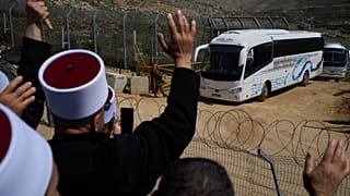 حافلات تقل أعضاء من الطائفة الدرزية السورية تحظى بالترحيب من قبل رجال الدين الدروز على الحدود مع سوريا، أثناء دخولهم قرية مجدل شمس في الجولان المحتل الجمعة 14 مارس 2025