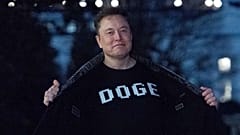 DOSYA - Elon Musk, 9 Mart 2025 tarihinde Washington'da Beyaz Saray'ın güney bahçesinde yürürken üzerinde "DOGE" yazan tişörtünü medyaya gösterdi