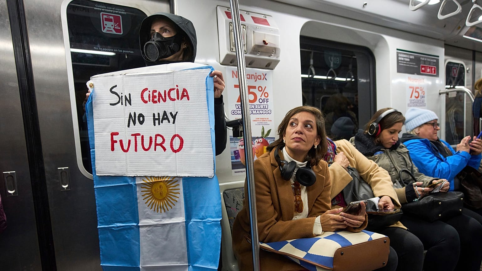 Une femme tient une pancarte dans une rame de métro, à Buenos Aires, Argentine, mercredi 28 mai 2025