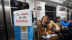 Bir kadın, 28 Mayıs 2025 Çarşamba günü Buenos Aires, Arjantin'de bir metro vagonunda bir tabela tutuyor
