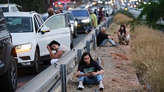 إسرائيليون يقفون على جانب الطريق السريع وقت انطلاق صفارات الإنذار تحذيرًا بعد إطلاق صاروخ من اليمن، في تل أبيب، إسرائيل، الثلاثاء 13 مايو 2025