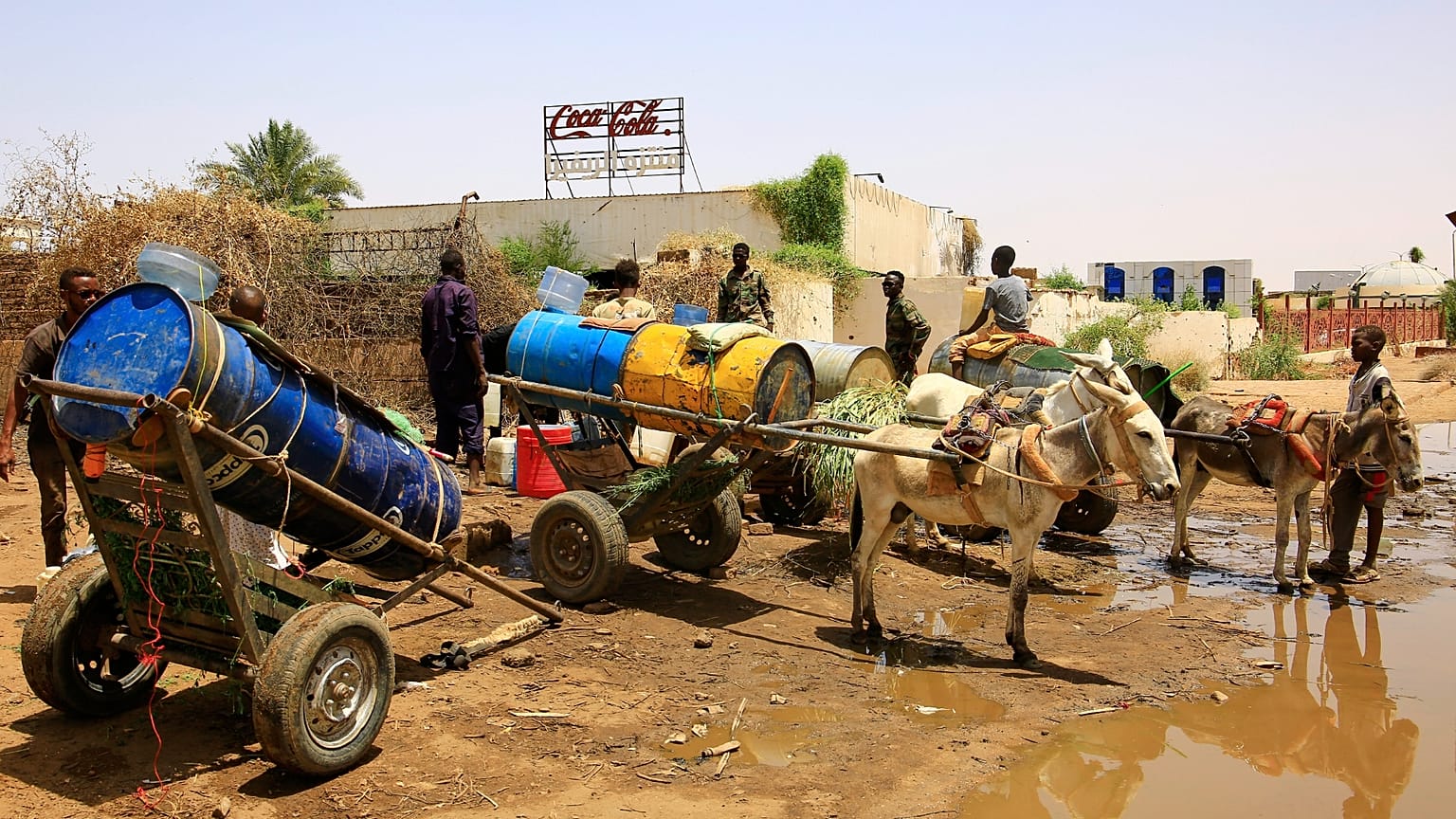 أشخاص يملأون حاويات المياه في نقطة توزيع بسبب انقطاع المياه في الخرطوم، السودان، الأحد، 25 مايو/أيار 2025. (أسوشيتد برس)