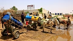 أشخاص يملأون حاويات المياه في نقطة توزيع بسبب انقطاع المياه في الخرطوم، السودان، الأحد، 25 مايو/أيار 2025. (أسوشيتد برس)
