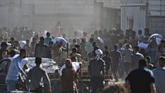 Filistinliler, Çarşamba günü Orta Gazze Şeridi'ndeki Zawaida'da BM Dünya Gıda Programı deposunu bastıktan sonra un çuvalları taşıyor.