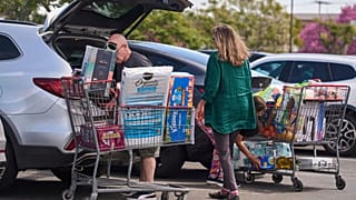 Burbank, Kaliforniya'daki Costco Wholesale mağazasında insanlar erzaklarını araçlarına yüklüyor. 10 Nisan 2025.