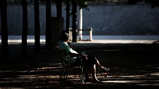  A man smokes a cigarette as he sits in the Tuileries Garden in Paris, 13 August 2016