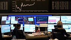 Broker look at video screens at the stock market in Frankfurt, Germany, Wednesday, April 16, 2025.