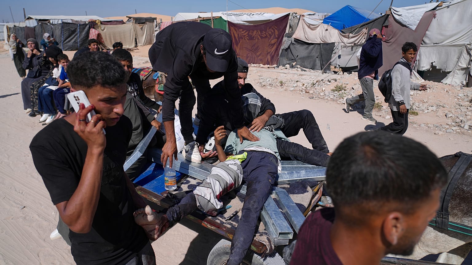 فلسطينيون يحملون رجلًا مصابًا بعد إطلاق النار عليه في مركز لتوزيع المساعدات تديره مؤسسة غزة الإنسانية في خان يونس  29 مايو/أيار 2025. 