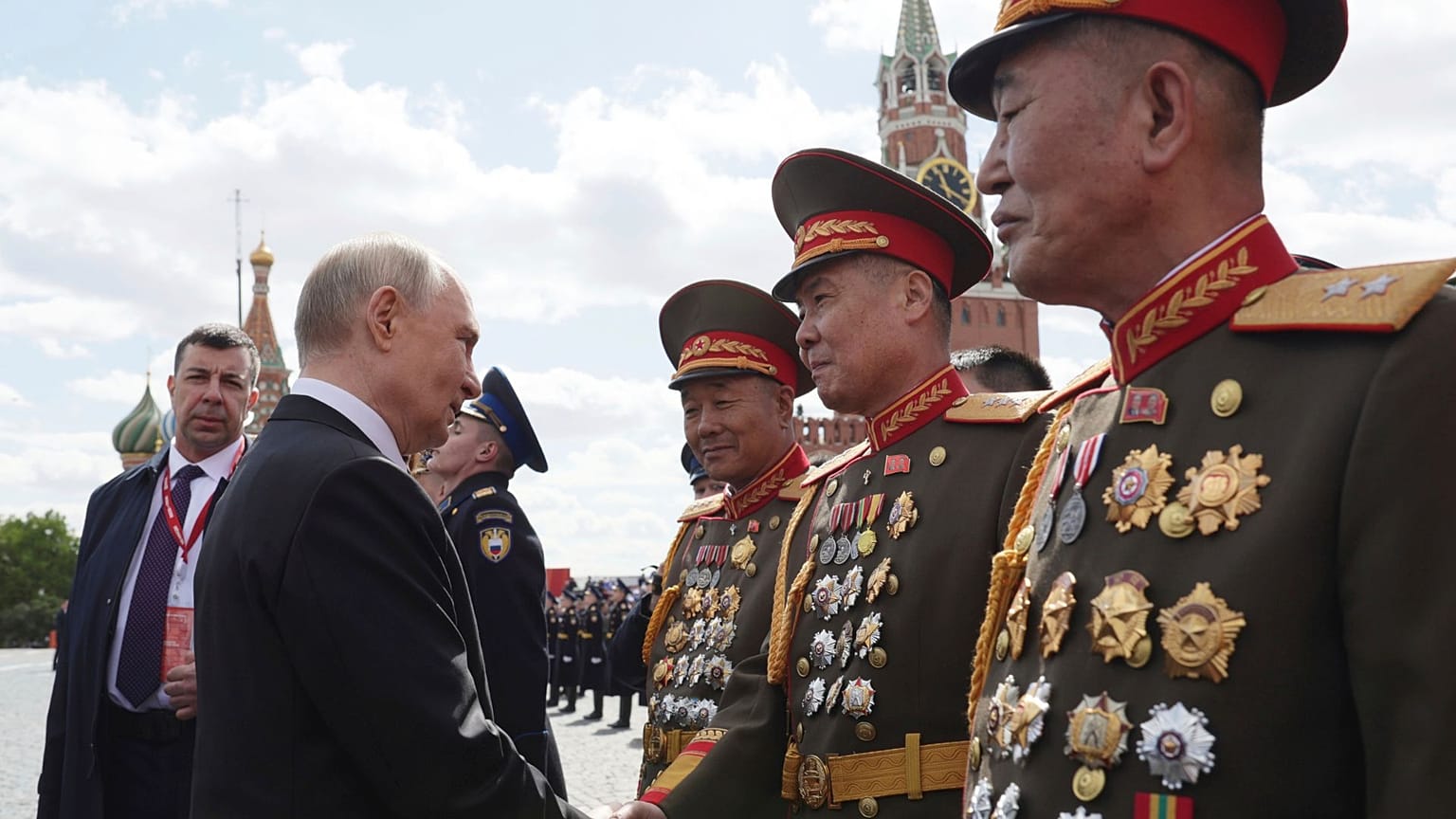 O Presidente russo, Vladimir Putin, fala com oficiais norte-coreanos após a parada militar do Dia da Vitória em Moscovo, Rússia, 9 de maio de 2025.
