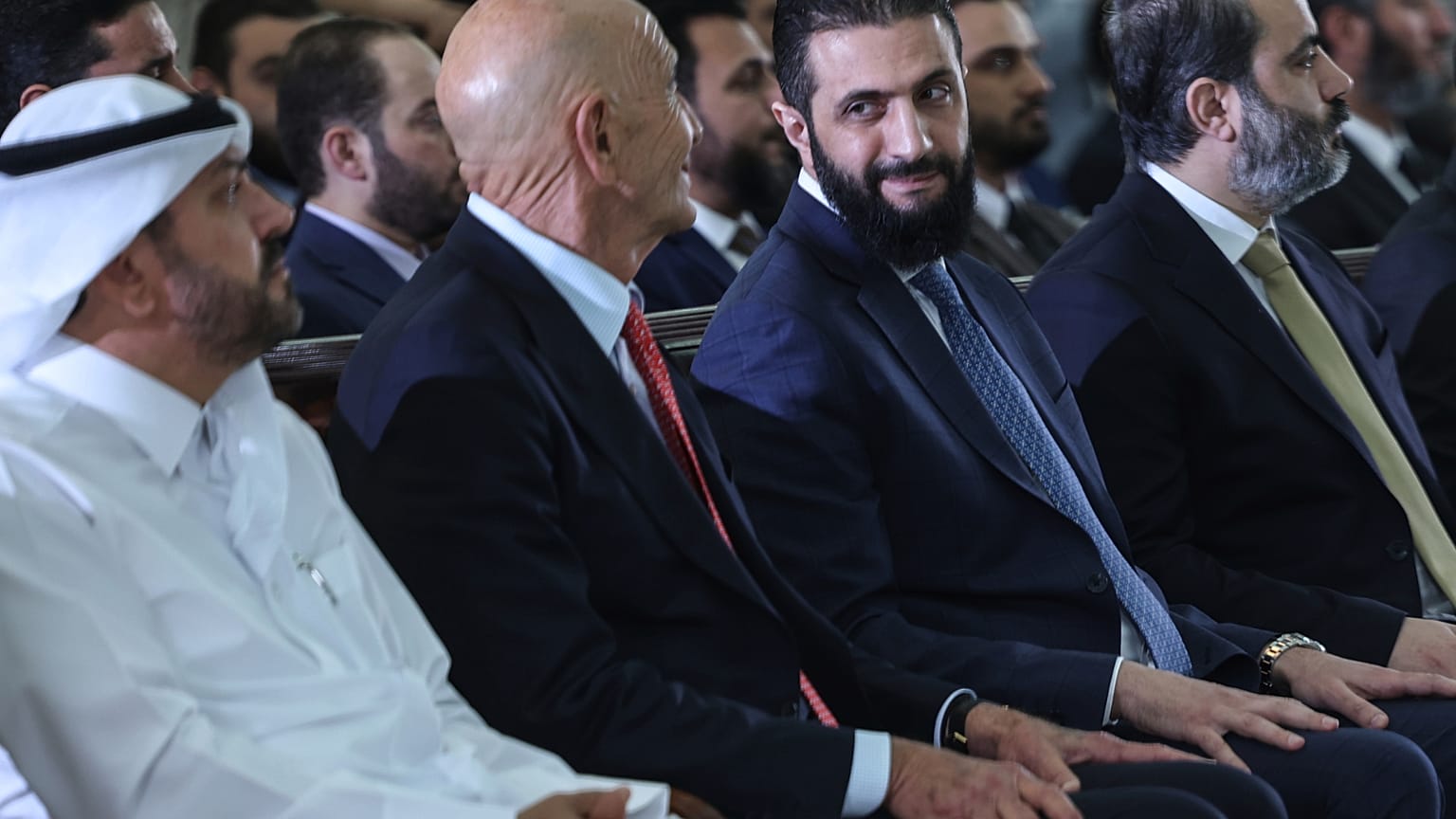 الرئيس السوري المؤقت أحمد الشرع ينظر إلى المبعوث الخاص إلى سوريا توم باراك أثناء حضو توقيع اتفاقية قطرية وتركية وأمريكية لتطوير مشروع للطاقة  29 مايو/أيار 2025