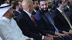 الرئيس السوري المؤقت أحمد الشرع ينظر إلى المبعوث الخاص إلى سوريا توم باراك أثناء حضو توقيع اتفاقية قطرية وتركية وأمريكية لتطوير مشروع للطاقة  29 مايو/أيار 2025