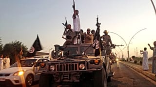 Combatentes do chamado grupo Estado Islâmico num veículo roubado das forças de segurança iraquianas na cidade de Mossul, no norte do país, a 23 de junho de 2014